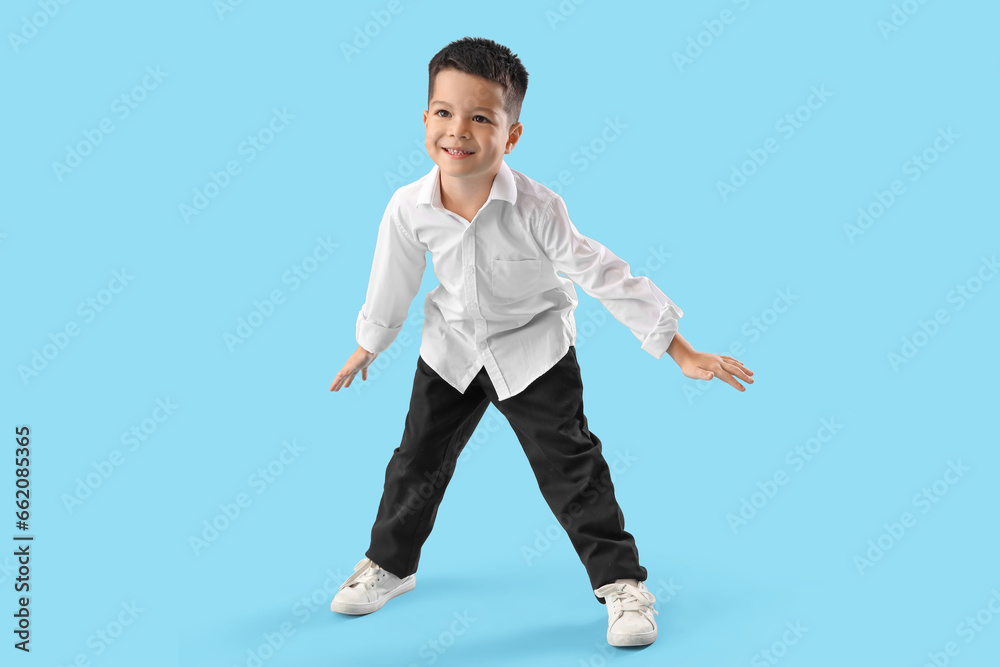 Sticker Little Asian boy dancing on blue background