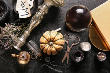 Witch's magic attributes with pumpkin on dark background