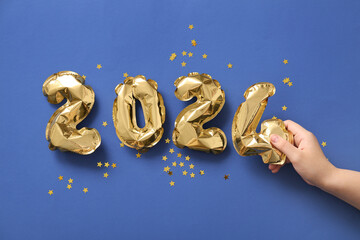 Woman with figure 2024 made of balloons on blue background