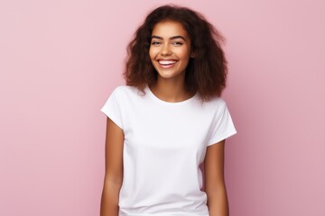 Fototapeta premium A happy woman in a white t-shirt posing against a vibrant pink backdrop