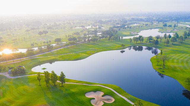 Golf course sport Aerial top view, golf field landscape with sunrise view in the morning shot. Bangkok Thailand, Golf course in fairway and putting green, sunny sky