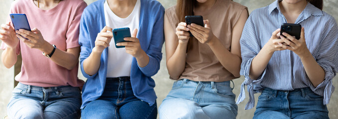 Group of young women using mobile phone. Young people sitting together obsessed with devices online, asian using laptops and smartphones, digital life and gadgets overuse concept.