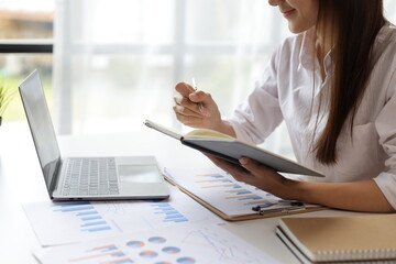 Fototapeta premium Woman working with laptop and paperwork in office.