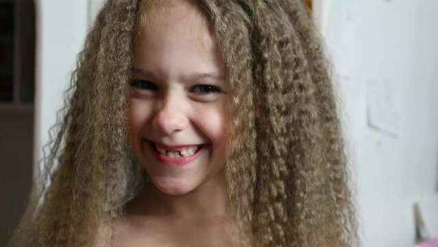 Cute little girl makes faces at the camera. Close-up. Portrait of a 6-year-old rebec