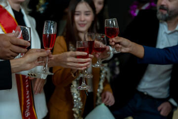 Group of office workers celebrate Christmas and New Year by dancing and drinking wine. Group of international friends and boss dancing with employees.