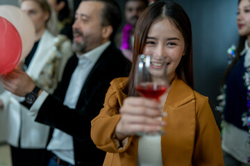 Group of office workers celebrate Christmas and New Year by dancing and drinking wine. Group of international friends and boss dancing with employees.