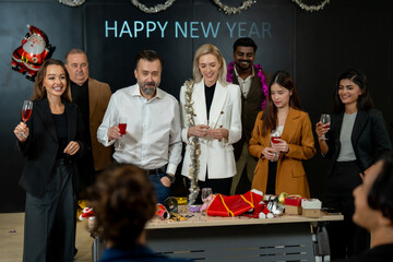 Group of office workers celebrate Christmas and New Year by dancing and drinking wine. Group of international friends and boss dancing with employees.