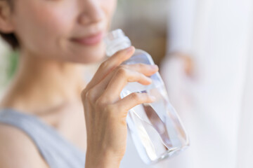 ペットボトルの水を飲む女性