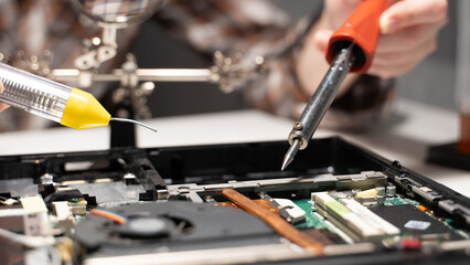 a master with a soldering iron soldering a chip