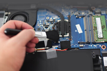 Fototapeta na wymiar omputer technician Laptop motherboard repairman is using a converter to clean the motherboard.