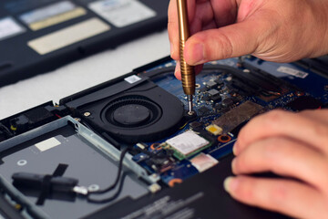 technician computer technician Laptop motherboard repairman using screwdriver to remove computer equipment To take it out and repair it so it can be used.