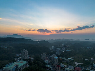 Aerial view of sunset at Wuji Tianyuan Temple by drone in Tamsui, New Taipei City, Taiwan. Beautiful weather, blue sky and mountains.