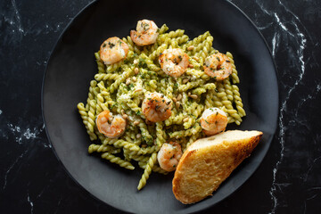 A top down view of a plate of gemelli shrimp pesto.