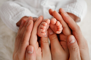 Baby's feet in in the hands of parents. Closeup photo. Happy Family concept.  - Powered by Adobe