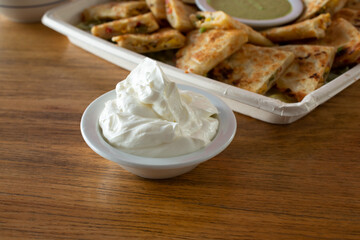 A view of a condiment cup of sour cream.
