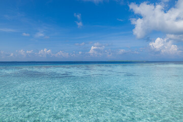 Indian Ocean, beautiful calm turquoise water and blue sky with few clouds. Tropical beach panorama,...