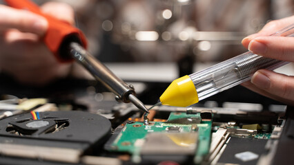a master with a soldering iron soldering a chip