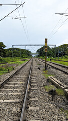 Obraz premium train railroad tracks in the countryside surrounded by greenery during a summer day