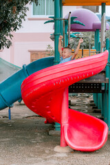 Happy healthy boy playing on playground equipment.