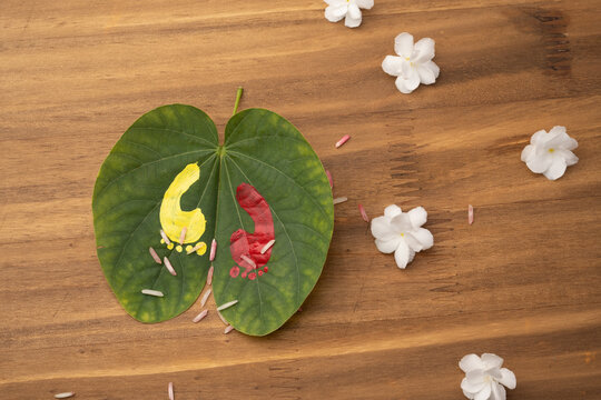 Maa Lakshmi or Godess footprint painted on apta leave. Hindu festival dasara dushera celebration. with marogold flowers. 