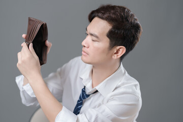 Depressed businessman holding the empty wallet and crying. Termination and unemployment concept.