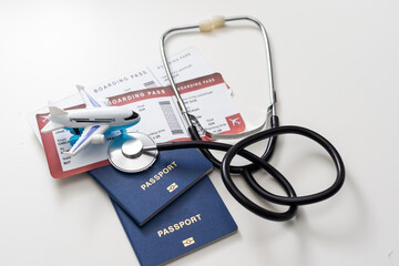 health insurance in travel concept. medical care abroad. stethoscope, toy airplane and passports - obrazy, fototapety, plakaty
