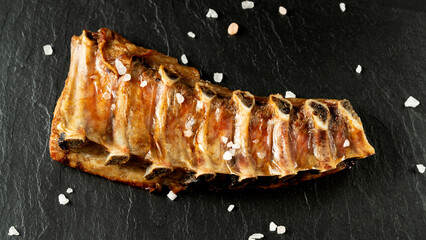pork ribs with spices on a black background. the concept of recipes and restaurant menus