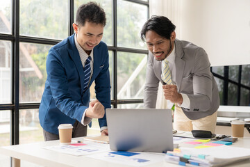 Two business people working together to analyze, work together to discuss company financial statistics, brainstorm ideas, and graph documents on the table.