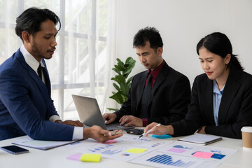 Two business people working together to analyze, work together to discuss company financial statistics, brainstorm ideas, and graph documents on the table.