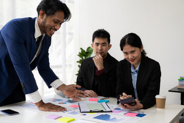 Two business people working together to analyze, work together to discuss company financial statistics, brainstorm ideas, and graph documents on the table.