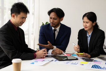 Two business people working together to analyze, work together to discuss company financial statistics, brainstorm ideas, and graph documents on the table.