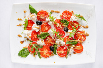 Caprese salad with mozzarella cheese, tomatoes and basil