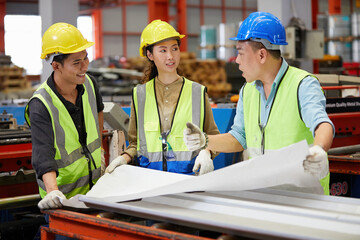 factory workers or engineers planning from work on blueprint drawing paper in the factory
