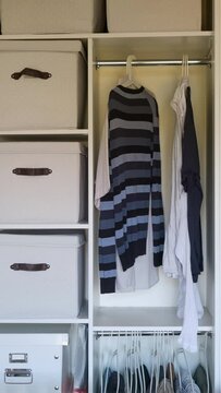 Putting things in order and hanging men's clothes, animation. Filling and arrangement of clothes in the home closet, vertical stop motion.