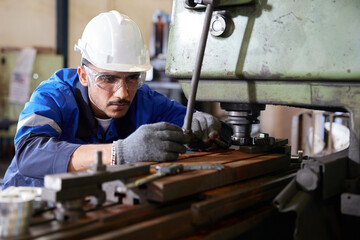 factory worker or technician checking and control lathe machine in factory