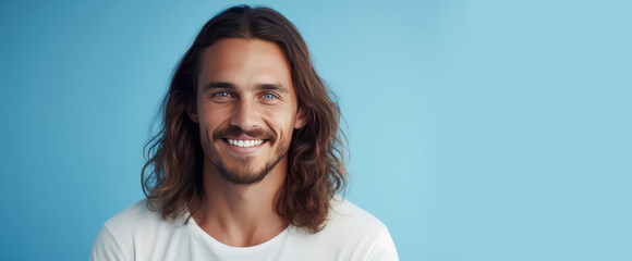 Handsome elegant sexy smiling Caucasian man with perfect skin and long hair, on a light blue...