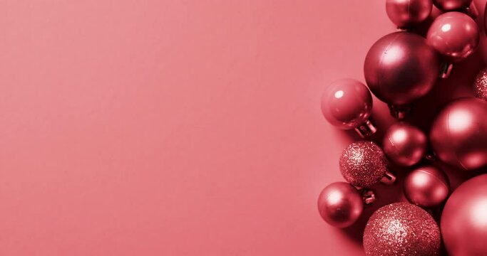 Video of red baubles christmas decorations with copy space on red background