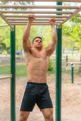 Obraz premium A strong man demonstrates his power while exercising on monkey bars, showcasing his fitness and strength