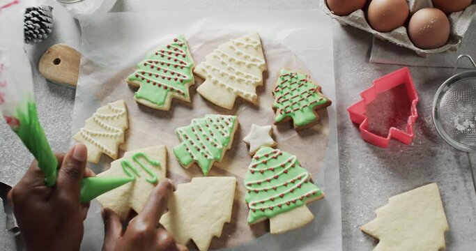 Video of christma cookies being decorated with green sugar icing with copy space on white background