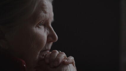 shot of old woman sitting near window and nods