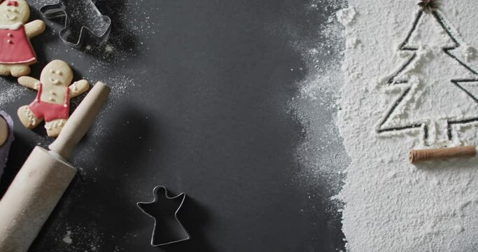 Video of christmas cookies and christmas tree drawn in flour and copy space on black background