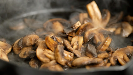 Fried champignons mushrooms in pan