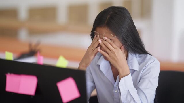 Young Asian Female In 20s Stressed At Work In Front Of Computer, Overworked And Exhausted