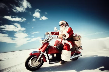 Selbstklebende Fototapeten Full length of Santa Claus who ride vintage motorbike deliver gifts Christmas eve on the road © zamuruev