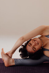 Young pregnant woman doing yoga exercises and meditating at studio. Health care, mindfulness and wellness concept.