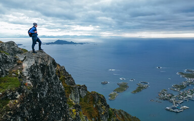 Fototapeta premium Hiker with backpack enjoying sunset landscape in Lofoten Norway