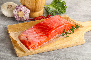 Raw salmon fillet over board