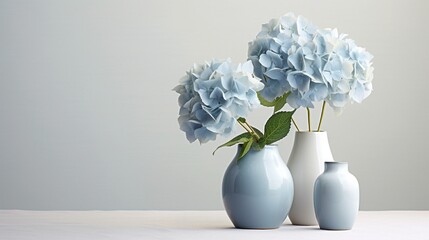 An arrangement of soft blue hydrangea blooms grouped together on a serene light gray background, creating a soothing and harmonious visual experience.