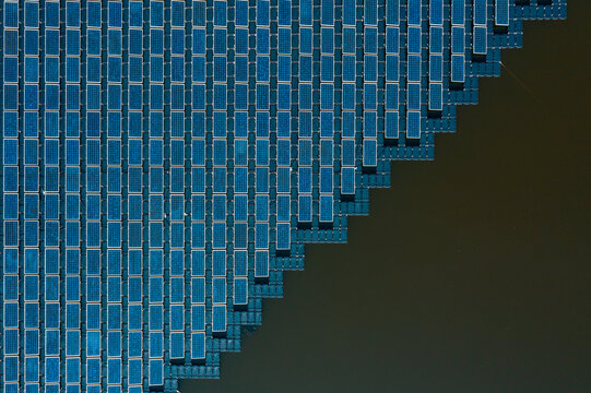 Aerial top view or hydro-floating solar hybrid of solar cells floating on the water in solar power station, solar photovoltaic, hydroelectric dam, alternative renewable energy
