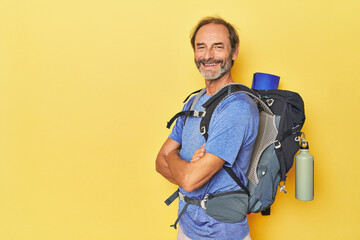 Adventurous man with mountain backpack in studio